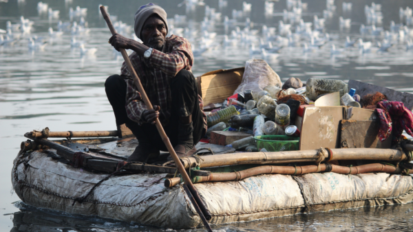 Man in floating recycled raft.