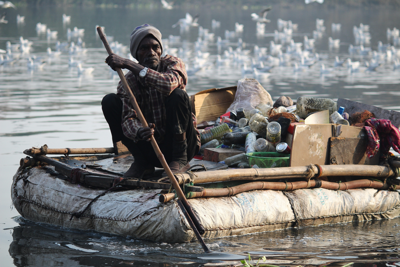 Man in floating recycled raft.